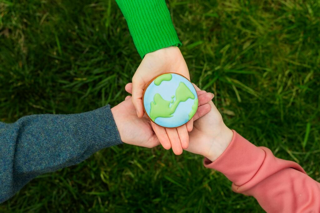 Earth Day concept. Hands hold gingerbread in the shape of the Earth. Care for the environment.